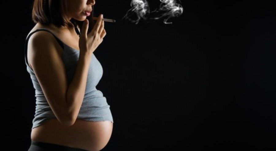 Беременная девушка курит