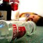 Девушка лежит на полу рядом с бутылками