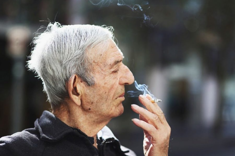 Старик курит сигарету