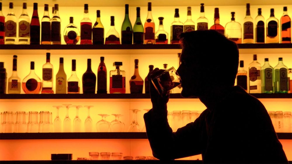 Мужчина пьет в баре