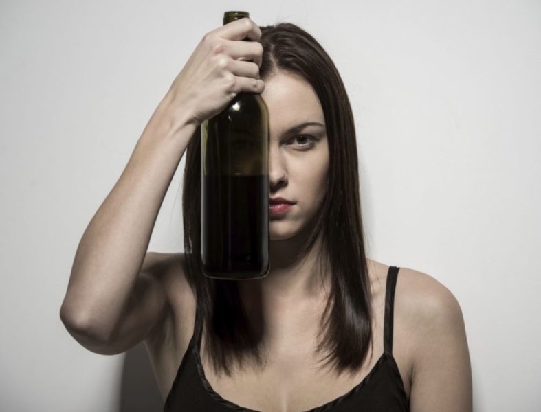 Девушка держит бутылку вина