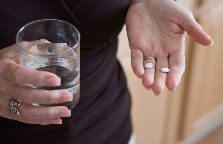 Таблетки с стакан воды в руках