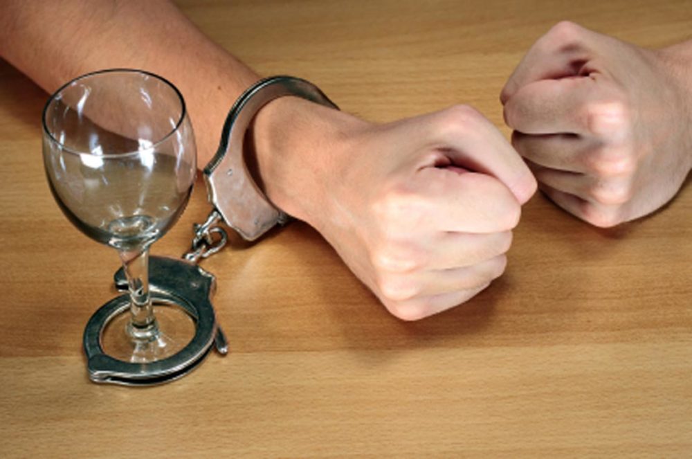 Рука прикована наручниками к бокалу
